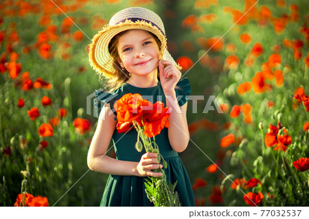 Girl in dress and straw hat outdoor At Poppy Field 77032537