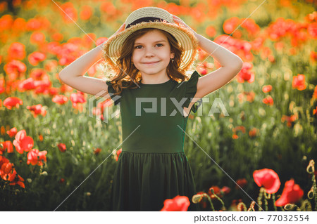 Girl in dress and straw hat outdoor At Poppy Field 77032554