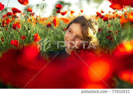 Girl in dress and straw hat outdoor At Poppy Field 77032631
