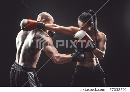 Shirtless Woman exercising with trainer at boxing and self defen Shirtless Woman exercising with trainer at boxing and self defen 77032791