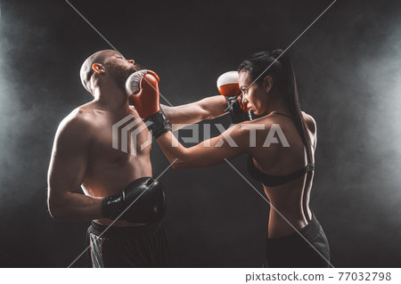 Shirtless Woman exercising with trainer at boxing and self defen Shirtless Woman exercising with trainer at boxing and self defen 77032798