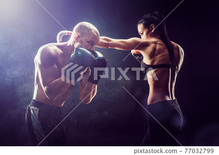 Shirtless Woman exercising with trainer at boxing and self defen Shirtless Woman exercising with trainer at boxing and self defen 77032799