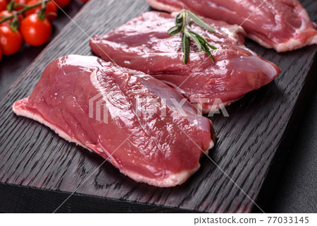 Raw duck breast with herbs and spices on a dark concrete background Raw duck breast with herbs and spices on a dark concrete background 77033145