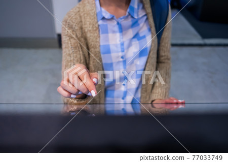 Woman using multimedia touchscreen display of interactive kiosk at exhibition Woman using multimedia touchscreen display of interactive kiosk at exhibition 77033749