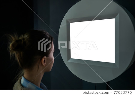 White screen concept - woman looking at blank white display wall at exhibition 77033770