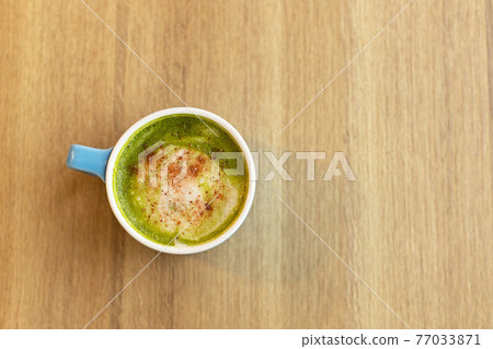 Blue cup with green tea matcha latte, with freeze-dried strawberries on wooden table, copy space. Healthy nutrition concept, drinks with vegetable or cow's milk, vegan beverages. Place for text 77033871