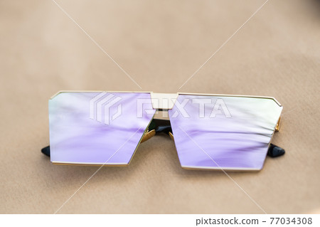 Oversized sunglasses model with pink flat lenses shoot outside in a sunny day closeup . Selective focus Oversized sunglasses model with pink flat lenses shoot outside in a sunny day closeup . Selective focus 77034308
