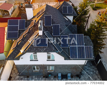 Aerial view of solar photovoltaic panels on a house roof 77034802