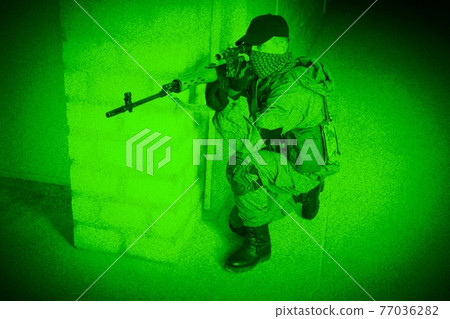 Mercenary sniper firing sniper rifle inside the building. View through night vision. Mercenary sniper firing sniper rifle inside the building. View through night vision. 77036282