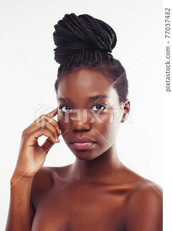 young pretty african american woman with natural makeup taking care of her skin isolated on white background 77037482