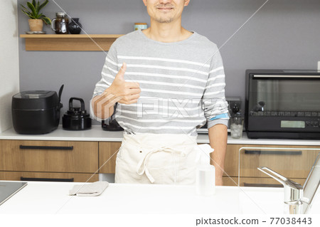 A man standing in the kitchen A man standing in the kitchen 77038443