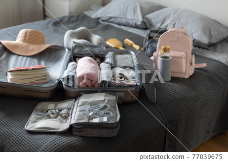 Suitcase technique wires equipment on bed. Package or storage with stuff, clothes and accessories 77039675