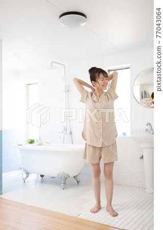 A smiling young woman in pajamas 77043064