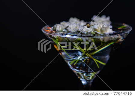 白夫人銀行的玫瑰漂浮在裝滿水的雞尾酒杯中 白夫人銀行的玫瑰漂浮在裝滿水的雞尾酒杯中 77044716
