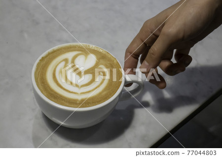 A cup of latte on the table 77044803