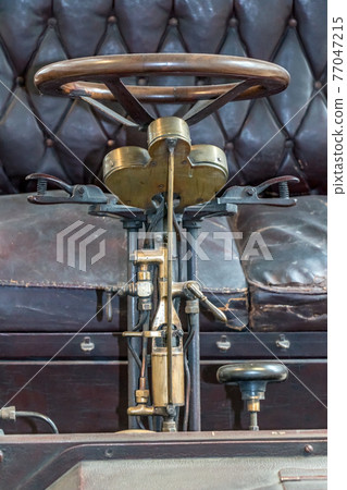 A steering wheel with mechanism of gear control on a historic car. Control mechanism on veteran car. 77047215