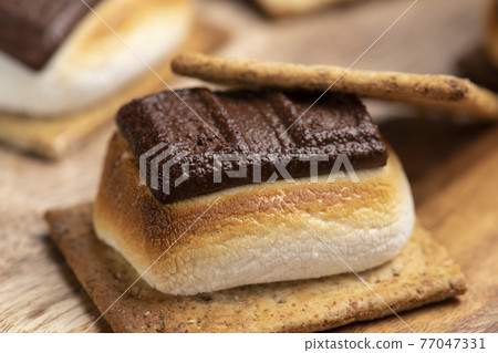 S'more with baked marshmallows and chocolate sandwiched between crackers 77047331