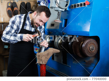 Male worker repairing shoe Male worker repairing shoe 77048000