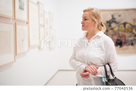 Closeup on mature female visiting museum Closeup on mature female visiting museum 77048536