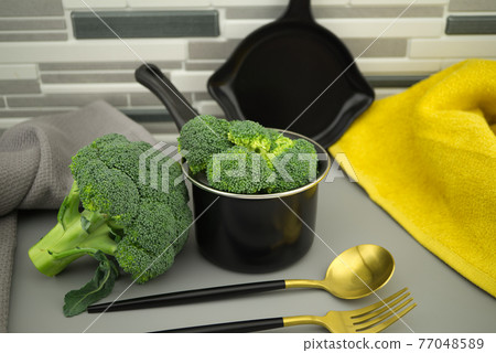 Prepare broccoli for eating on the kitchen table Prepare broccoli for eating on the kitchen table 77048589