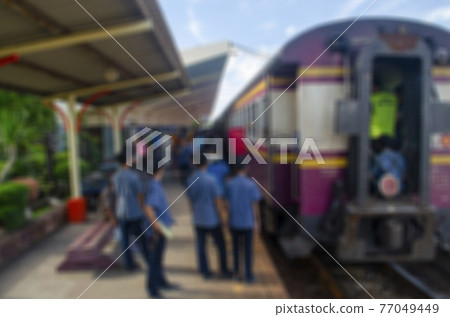 The image is blurred, the passengers are waiting to board the train at the station. The image is blurred, the passengers are waiting to board the train at the station. 77049449