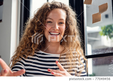 Close up shot of happy smiling Caucasian woman talking while making video call conference at home Close up shot of happy smiling Caucasian woman talking while making video call conference at home 77049456