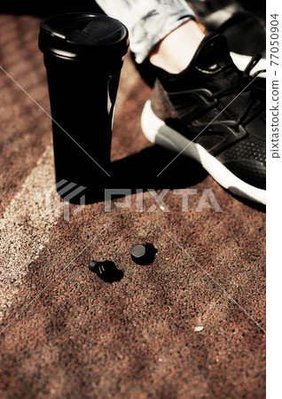 New technology sport wearable accessories for runners: fitness sports wireless earphones, running shoes. Earbuds, headphones. Tech run gear, smart jogging. Fitness Woman Relaxing After Training New technology sport wearable accessories for runners: fitness sports wireless earphones, running shoes. Earbuds, headphones. Tech run gear, smart jogging. Fitness Woman Relaxing After Training 77050904