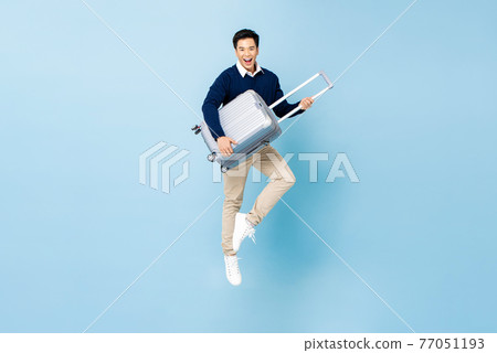 Young energized Asian tourist man with baggage jumping ready to travel 77051193