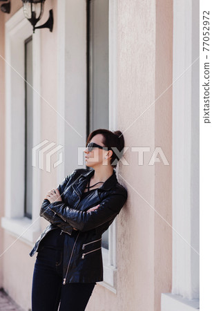 stylish brunette woman in a leather jacket stylish brunette woman in a leather jacket 77052972