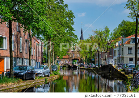 Cars on canal embankment in street of Delft. Delft, Netherlands 77053161