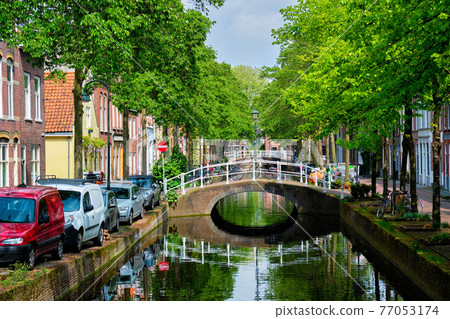 Cars on canal embankment in street of Delft. Delft, Netherlands Cars on canal embankment in street of Delft. Delft, Netherlands 77053174