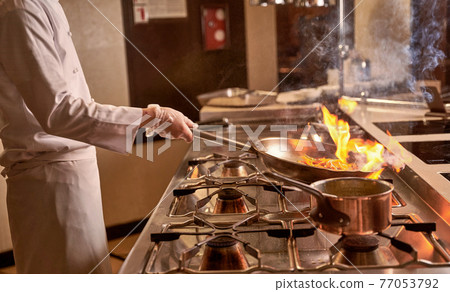 Fire burning inside a pan with peppers 77053792