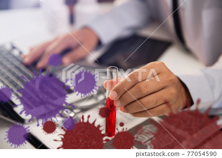 Medical or research scientist or doctor using looking at a test tube of clear solution in a lab or laboratory. 77054590