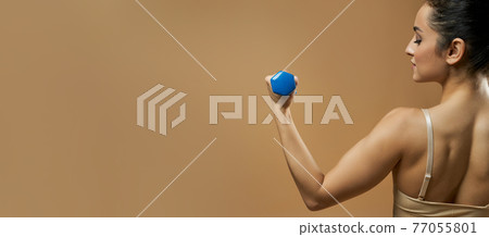Website header of Athletic young woman doing exercise with dumbbell 77055801