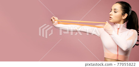 Website header of Charming young woman in sportswear using fitness band 77055822