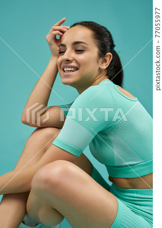 Joyful young woman in sportswear posing in studio 77055977