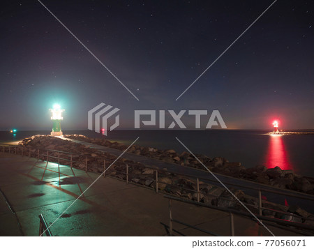 Bright light breakwater tower at harbor entrance in Rostock Warnemunde Bright light breakwater tower at harbor entrance in Rostock Warnemunde 77056071