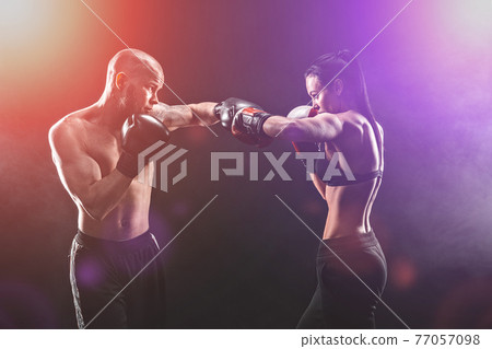 Shirtless Woman exercising with trainer at boxing and self defen Shirtless Woman exercising with trainer at boxing and self defen 77057098