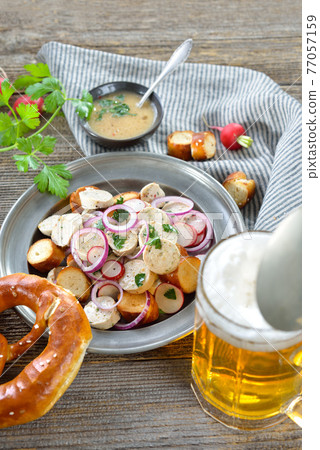 Bavarian beer garden snack with veal sausage salad and pretzels, served with a mug of lager beer Bavarian beer garden snack with veal sausage salad and pretzels, served with a mug of lager beer 77057159