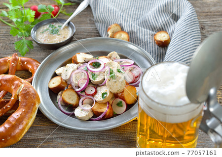 Bavarian beer garden snack with veal sausage salad and pretzels, served with a mug of lager beer Bavarian beer garden snack with veal sausage salad and pretzels, served with a mug of lager beer 77057161