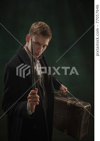 Young man in art action isolated on dark green background. Retro style, comparison of eras concept. 77057646