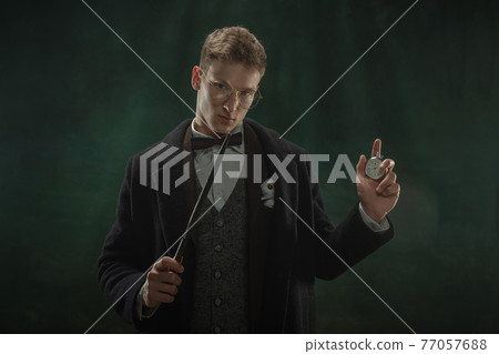 Young man in art action isolated on dark green background. Retro style, comparison of eras concept. 77057688