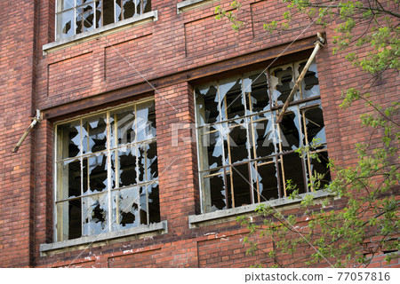 Closeup of broken windows on abandoned factory 77057816