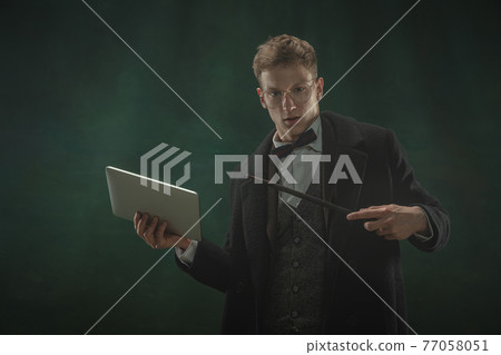 Young man in art action isolated on dark green background. Retro style, comparison of eras concept. Young man in art action isolated on dark green background. Retro style, comparison of eras concept. 77058051
