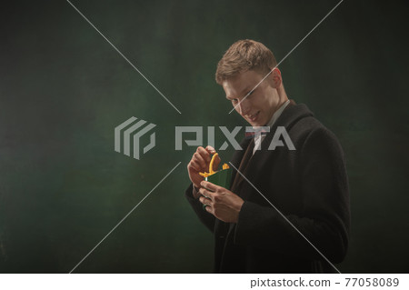 Young man in art action isolated on dark green background. Retro style, comparison of eras concept. 77058089