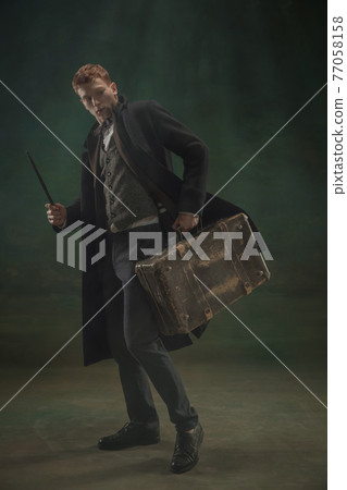 Young man in art action isolated on dark green background. Retro style, comparison of eras concept. 77058158