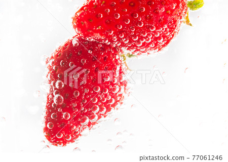 Delicious strawberries floating in champagne Delicious strawberries floating in champagne 77061246