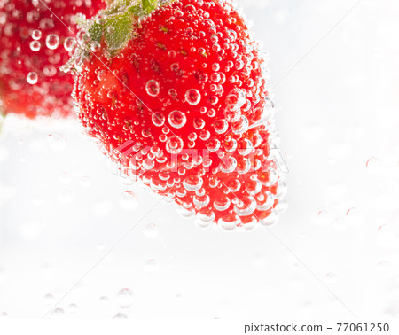 Delicious strawberries floating in champagne Delicious strawberries floating in champagne 77061250