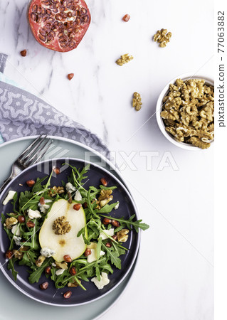 Fresh and healthy salad with arugula, gorgonzola cheese, pomegranate and pears. 77063882