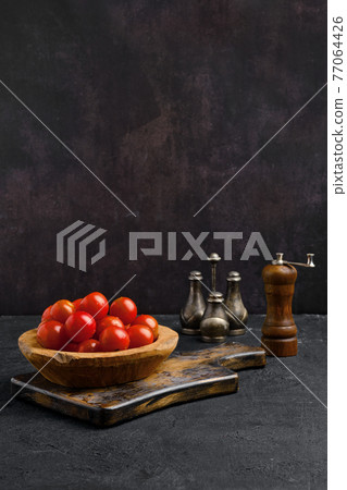 Fresh tomato cherry in wooden bowl Fresh tomato cherry in wooden bowl 77064426